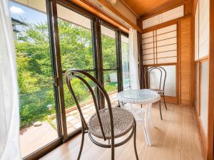 a room with a table and chairs and a window at STAY FUJI b in Yamanakako