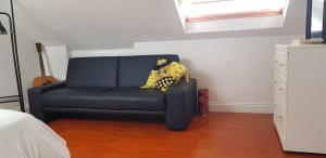 a blue couch with a yellow blanket on it in a room at 5 Tamar in Findon +1 photo