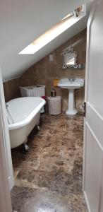 a bathroom with a bath tub and a sink at 5 Tamar in Findon