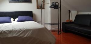 a bedroom with a bed and a black couch at 5 Tamar in Findon