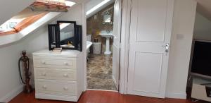 a hallway with a white dresser and a mirror at 5 Tamar in Findon