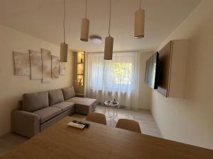 a living room with a table and a couch at MiLu Apartman in Győr