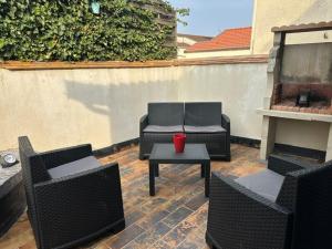 a patio with chairs and a table with a red cup on it at Floc & Sens in Chalons en Champagne