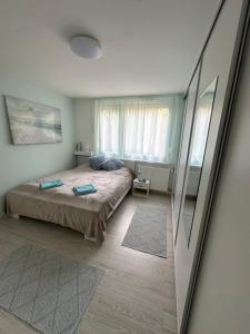 a bedroom with a bed and a large window at MiLu Apartman in Győr