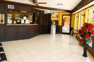 a lobby of a restaurant with a counter and flowers at Great Western Inn Pasadena in Pasadena