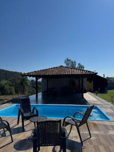 a group of chairs and a table next to a pool at CABANAS BELVEDERE SERRA DO RiO DO RASTRO in Lauro Müller