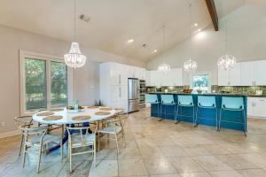 a large kitchen with a table and blue chairs at 4-Season Boathouse, Hot Tub! Guadalupe River Oasis in Seguin