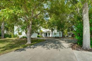 a house with trees in front of a driveway at 4-Season Boathouse, Hot Tub! Guadalupe River Oasis in Seguin