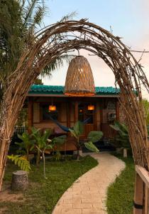 a wicker archway in front of a building at Tetebatu Sasak House Bungalow in Tetebatu
