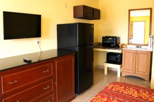 a kitchen with a black refrigerator and a microwave at Great Western Inn Pasadena in Pasadena