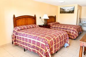a hotel room with two beds and a table at Great Western Inn Pasadena in Pasadena +19 photos