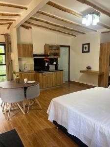 a bedroom with a bed and a table and a kitchen at Jardín Secreto in San Martín +27 photos