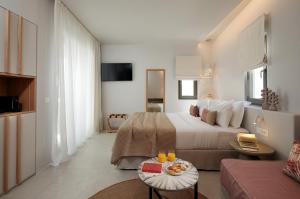 a bedroom with a bed and a living room at Anapollo Boutique Hotel Adults Only in Naxos Chora