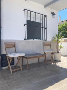 two chairs and a bench on a patio at Habitación Manzanilla in Sanlúcar de Barrameda
