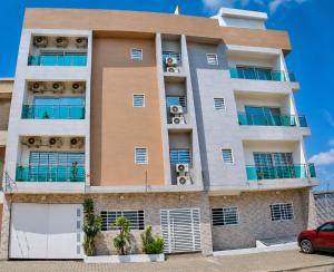 a building with balconies and a car parked in front at Studio américain Confort avec piscine in Abidjan