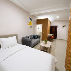 a hotel room with a bed and a couch at Studio américain Confort avec piscine in Abidjan +11 photos