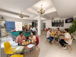 a group of people sitting at tables with a pool table at Studio américain Confort avec piscine in Abidjan