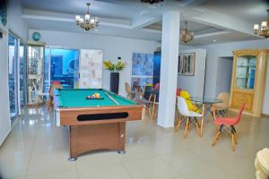 a room with a pool table and chairs at Studio américain Confort avec piscine in Abidjan
