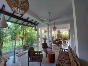a living room with chairs and a table and a large window at Randi Guest Mirissa in Mirissa