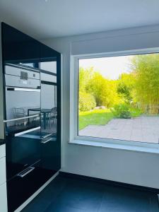 a kitchen with a large window and a view of a patio at Blick ins Grüne in Daisendorf