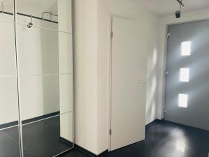 a closet with white cabinets and a door at Blick ins Grüne in Daisendorf +48 photos
