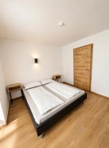 a bedroom with a large bed and a wooden door at Apartma 47 in Kobarid
