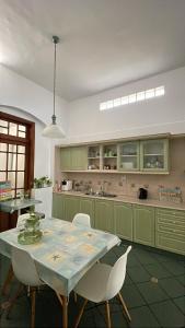 a kitchen with green cabinets and a table and chairs at aromasdelpandeazucar in Unquillo