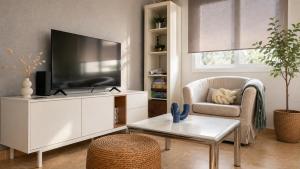 a living room with a tv and a chair and a table at CAROLA l, "Encantador apartamento de estilo marinero a 100m playa Catia" in Ribeira