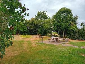 a picnic table in a field with trees at Kamer in Fermette Vlaamse Ardennen in Maarkedal