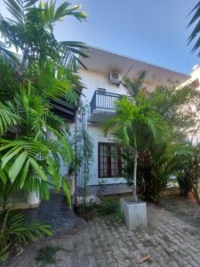 a white house with palm trees in front of it at Randi Guest Mirissa in Mirissa