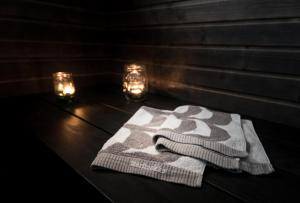 a pair of towels sitting on a table with lights at Villa Jokivarsi Bed & Breakfast in Vantaa