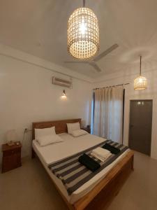 a bedroom with a bed and a chandelier at Randi Guest Mirissa in Mirissa