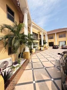 a building with a palm tree in front of it at Sonia Hotel in Accra