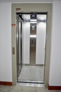a elevator door in a building with a mirror at Apartamentos Picea Azul in Vega de Espinareda