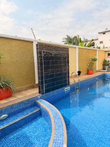 a large swimming pool with a black gate in a building at Sonia Hotel in Accra +6 photos