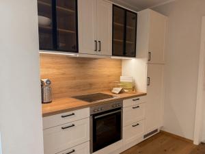 a kitchen with white cabinets and a stove at Ferienwohnung Seeperle am Dümmer See in Lembruch