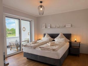 a bedroom with a large bed and a large window at Ferienwohnung Seeperle am Dümmer See in Lembruch