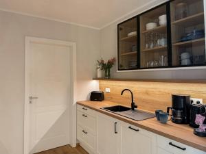 a kitchen with white cabinets and a sink at Ferienwohnung Seeperle am Dümmer See in Lembruch