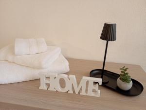 a table with a lamp and a sign that says home at Il Ginepro del Campidano in Nuraminis +15 photos