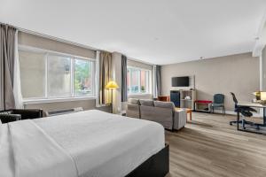 a hotel room with a bed and a living room at Ramada Plaza by Wyndham Montreal in Montreal
