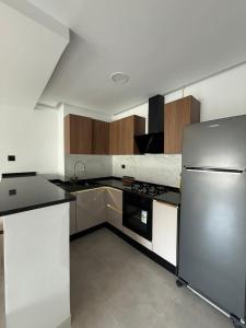 a kitchen with a stainless steel refrigerator and wooden cabinets at عين زغوان in La Marsa +12 photos