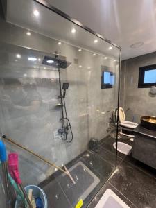 a bathroom with a shower with a glass wall at Mazen Zakaria apartment in Port Said +9 photos