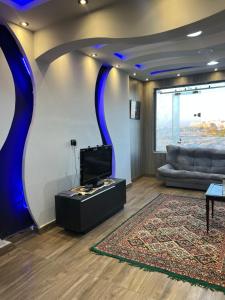 a living room with a couch and a tv at Mazen Zakaria apartment in Port Said