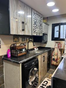 a kitchen with a black washer and a sink at Mazen Zakaria apartment in Port Said