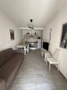 a living room with a couch and chairs and a kitchen at Mare Palau Sardegna in Palau