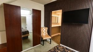 a room with a television on a wall with a chair at Bellinter House Hotel & Spa in Navan