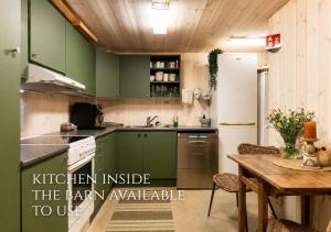 a kitchen with green cabinets and a wooden table at WonderInn Riverside in Årnes