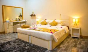 a bedroom with a large bed with a large mirror at South Ari Inn in Mandhoo