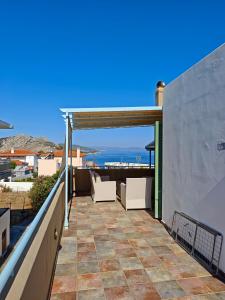 a patio with white chairs on a roof at MONI apartment in Perdika