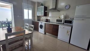 a kitchen with a table and a white refrigerator at Casa Yerbabuena in La Puebla de Cazalla
